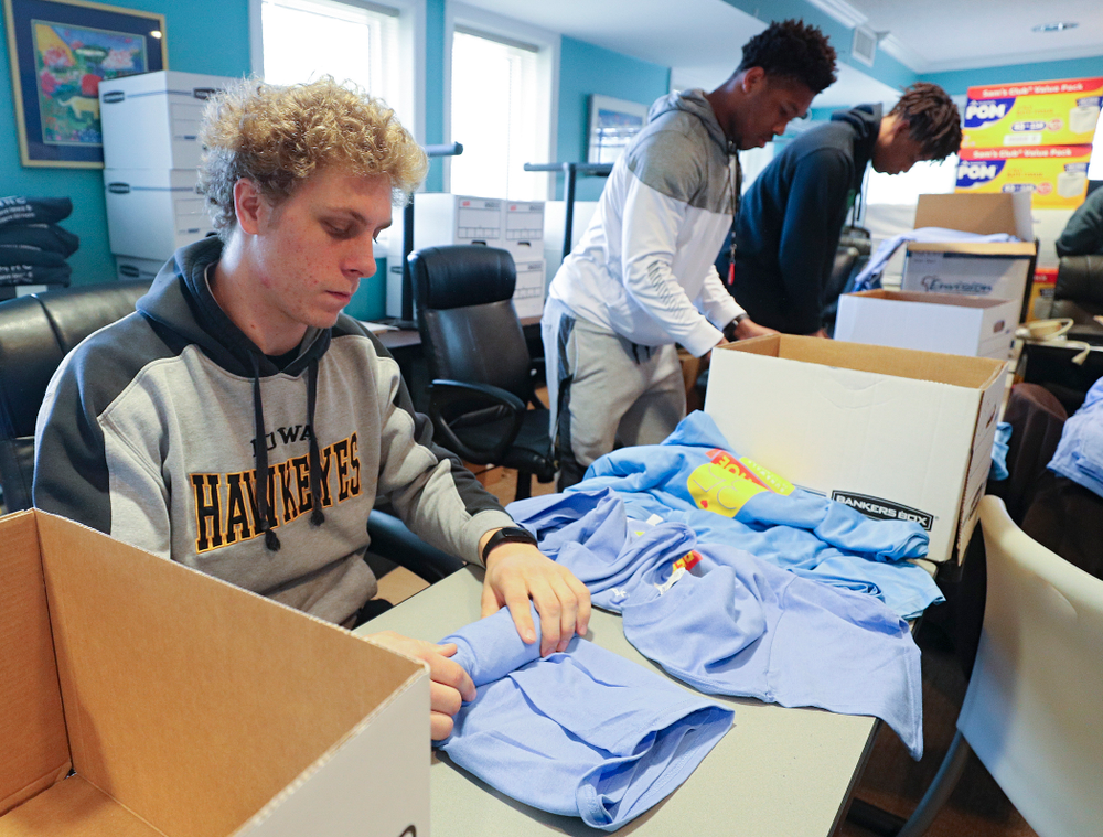 Iowa football players help fold shirts at the Ronald McDonald House for their Red Shoe Run/Walk during the 21st annual ISAAC Hawkeye Day of Caring in Iowa City on Sunday, Apr. 28, 2019. (Stephen Mally/hawkeyesports.com)