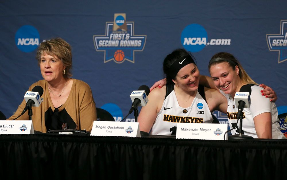 Iowa Hawkeyes forward Megan Gustafson (center) and guard Makenzie Meyer (right) hug as head coach Lisa Bluder talks during their press availability after winning their game in the first round of the 2019 NCAA Women's Basketball Tournament at Carver Hawkeye Arena in Iowa City on Friday, Mar. 22, 2019. (Stephen Mally for hawkeyesports.com)
