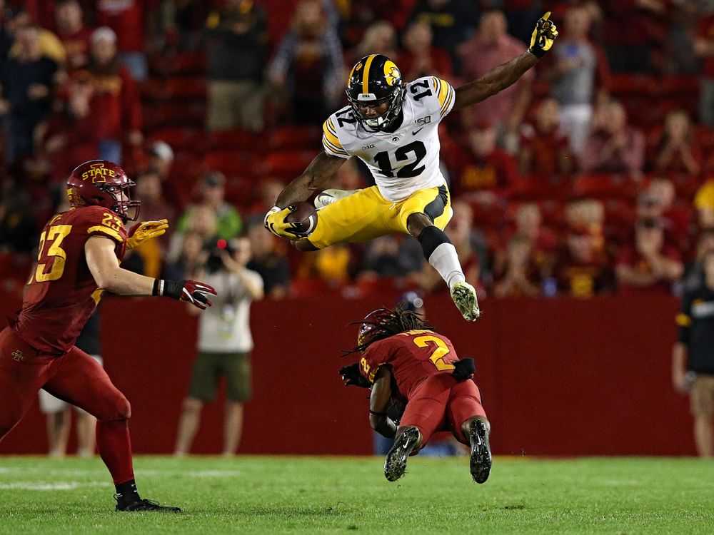 Iowa Hawkeyes wide receiver Brandon Smith (12) hurdles a defender during the third quarter of their Iowa Corn Cy-Hawk Series game at Jack Trice Stadium in Ames on Saturday, Sep 14, 2019. (Stephen Mally/hawkeyesports.com)