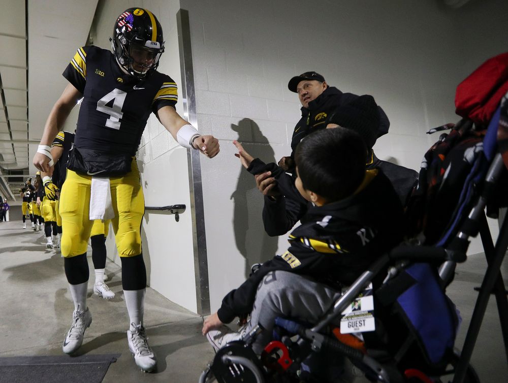 Iowa Hawkeyes quarterback Nate Stanley (4) fist bumps Kid Captain Mason Gonzalez before a game against Northwestern at Kinnick Stadium on November 10, 2018. (Tork Mason/hawkeyesports.com)