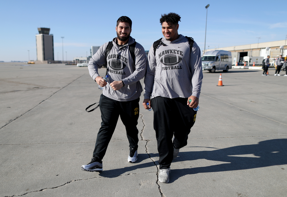 Iowa Hawkeyes defensive end A.J. Epenesa (94) and offensive lineman Tristan Wirfs (74) board the team plane at the Eastern Iowa Airport Saturday, December 21, 2019 on the way to San Diego, CA for the Holiday Bowl. (Brian Ray/hawkeyesports.com)
