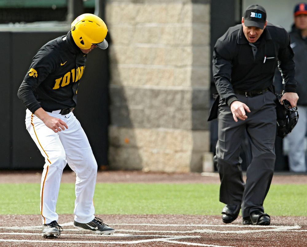 Iowa Hawkeyes right fielder Ben Norman (9) scores a run as the home plate umpire signals that the Illinois catcher blocked the plate during the second inning of their game against Illinois at Duane Banks Field in Iowa City on Saturday, Mar. 30, 2019. (Stephen Mally/hawkeyesports.com)