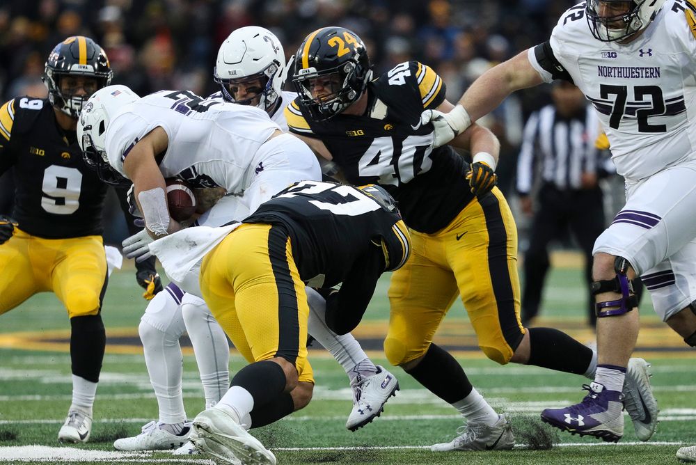 Iowa Hawkeyes defensive back Amani Hooker (27) and Iowa Hawkeyes defensive end Parker Hesse (40) make a tackle during a game against Northwestern at Kinnick Stadium on November 10, 2018. (Tork Mason/hawkeyesports.com)