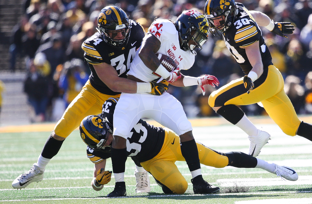 Iowa Hawkeyes linebacker Kristian Welch (34) and Iowa Hawkeyes defensive back Riley Moss (33) make a tackle during a game against Maryland at Kinnick Stadium on October 20, 2018. (Tork Mason/hawkeyesports.com)