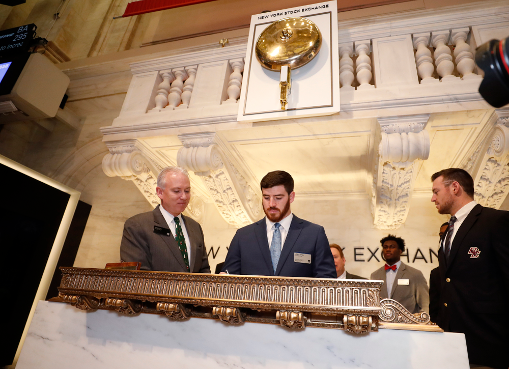 Iowa Hawkeyes linebacker Josey Jewell (43), defensive back Joshua Jackson (15), offensive lineman Sean Welsh (79) and head coach Kirk Ferentz ring the opening bell at the New York Stock Exchange Tuesday, December 26, 2017 in New York. (Brian Ray/hawkeyesports.com)