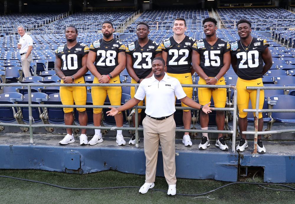 Iowa Hawkeyes running backs coach Derrick Foster with running backs Mekhi Sargent, Toren Young, Shadrick Byrd, Samson Evans, Tyler Goodson, and Keontae Luckett following the team photo Wednesday, December 25, 2019 at SDCCU Stadium in San Diego. (Brian Ray/hawkeyesports.com)