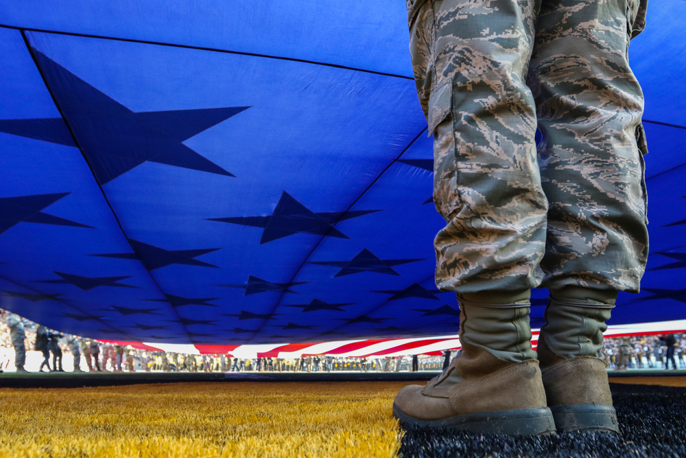 A U.S. Service Member helps hold an American flag during Iowa football vs Minnesota on Saturday, November 16, 2019 at Kinnick Stadium. (Lily Smith/hawkeyesports.com)