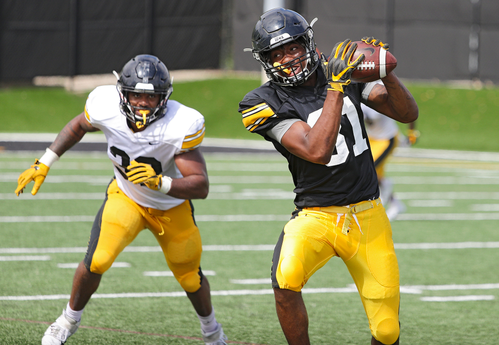 Iowa Hawkeyes wide receiver Desmond Hutson (81) pulls in a pass as linebacker Djimon Colbert (32) closes in during Fall Camp Practice No. 11 at the Hansen Football Performance Center in Iowa City on Wednesday, Aug 14, 2019. (Stephen Mally/hawkeyesports.com)