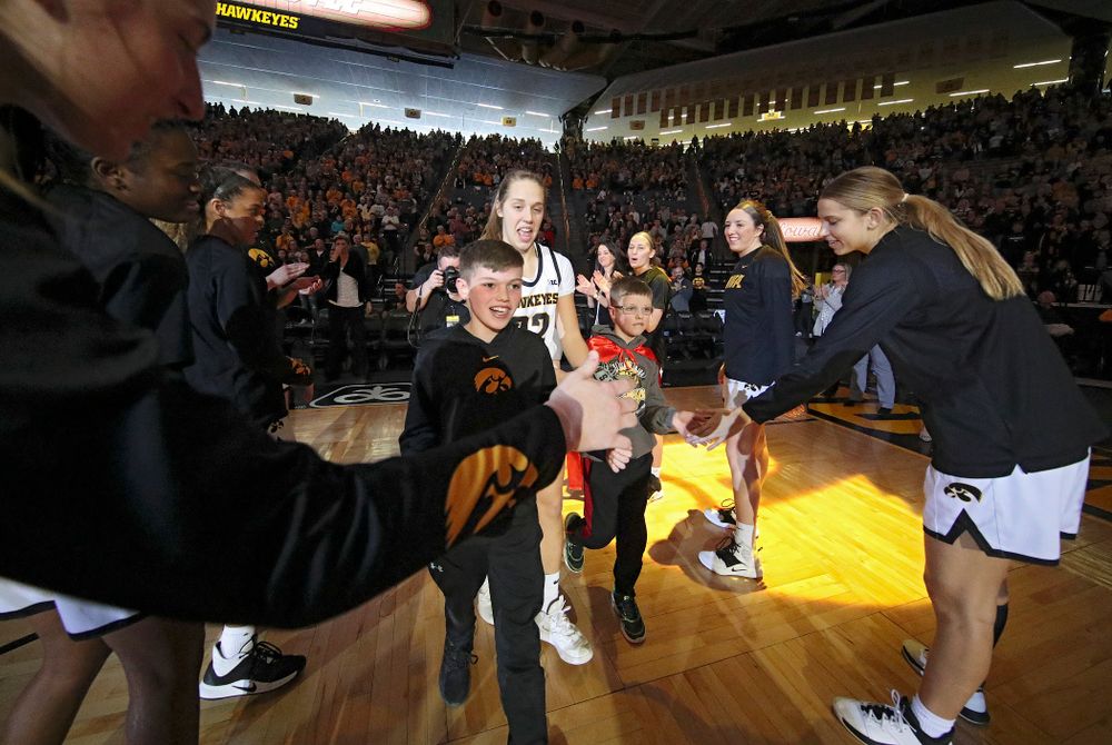 Iowa Hawkeyes guard Kathleen Doyle (22) is introduced with two Go Red for Women Movement Heart Champions before the start of their game at Carver-Hawkeye Arena in Iowa City on Sunday, January 26, 2020. (Stephen Mally/hawkeyesports.com)