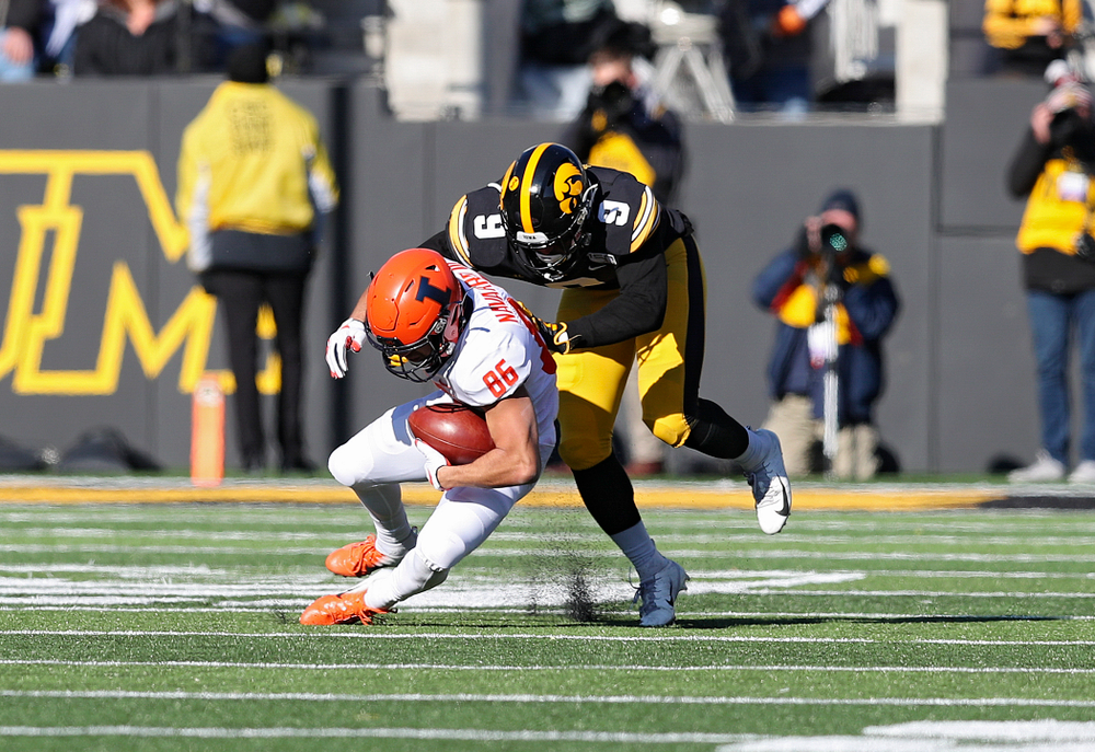 Iowa Hawkeyes defensive back Geno Stone (9) brings down Illinois Fighting Illini wide receiver Donny Navarro (86) during the third quarter of their game at Kinnick Stadium in Iowa City on Saturday, Nov 23, 2019. (Stephen Mally/hawkeyesports.com)