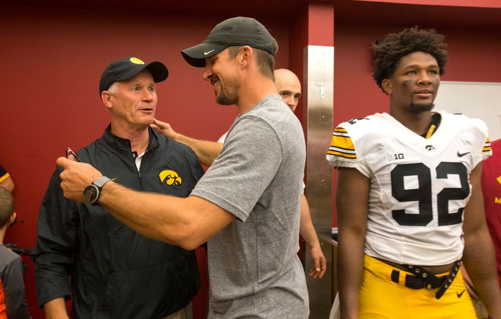 Former Iowa Hawkeyes tight end Dallas Clark talks with defensive line coach Reese Morgan as they celebrate their victory over the Iowa State Cyclones in the Iowa Corn Cy-Hawk Series Saturday, Sept. 12, 2015 at the Jack Trice Stadium in Ames. (Brian Ray/hawkeyesports.com)