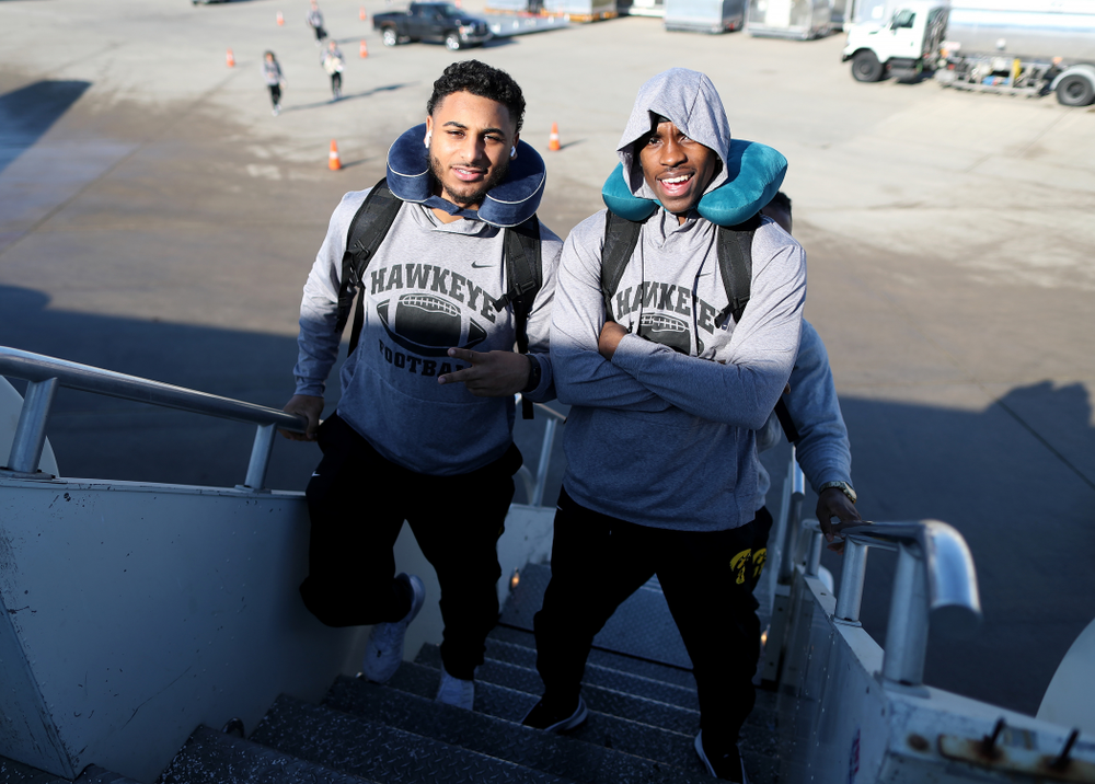 Iowa Hawkeyes defensive back Geno Stone (9) and defensive back Michael Ojemudia (11) board the team plane at the Eastern Iowa Airport Saturday, December 21, 2019 on the way to San Diego, CA for the Holiday Bowl. (Brian Ray/hawkeyesports.com)