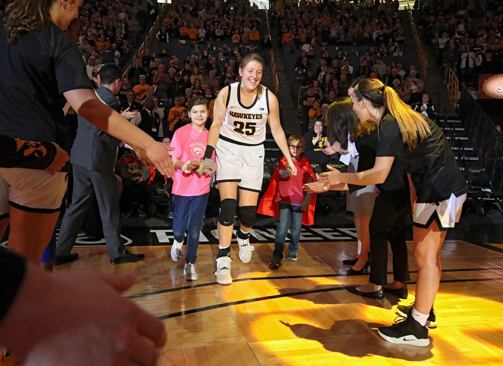 Iowa Hawkeyes forward Monika Czinano (25) is introduced with two Go Red for Women Movement Heart Champions before the start of their game at Carver-Hawkeye Arena in Iowa City on Sunday, January 26, 2020. (Stephen Mally/hawkeyesports.com)