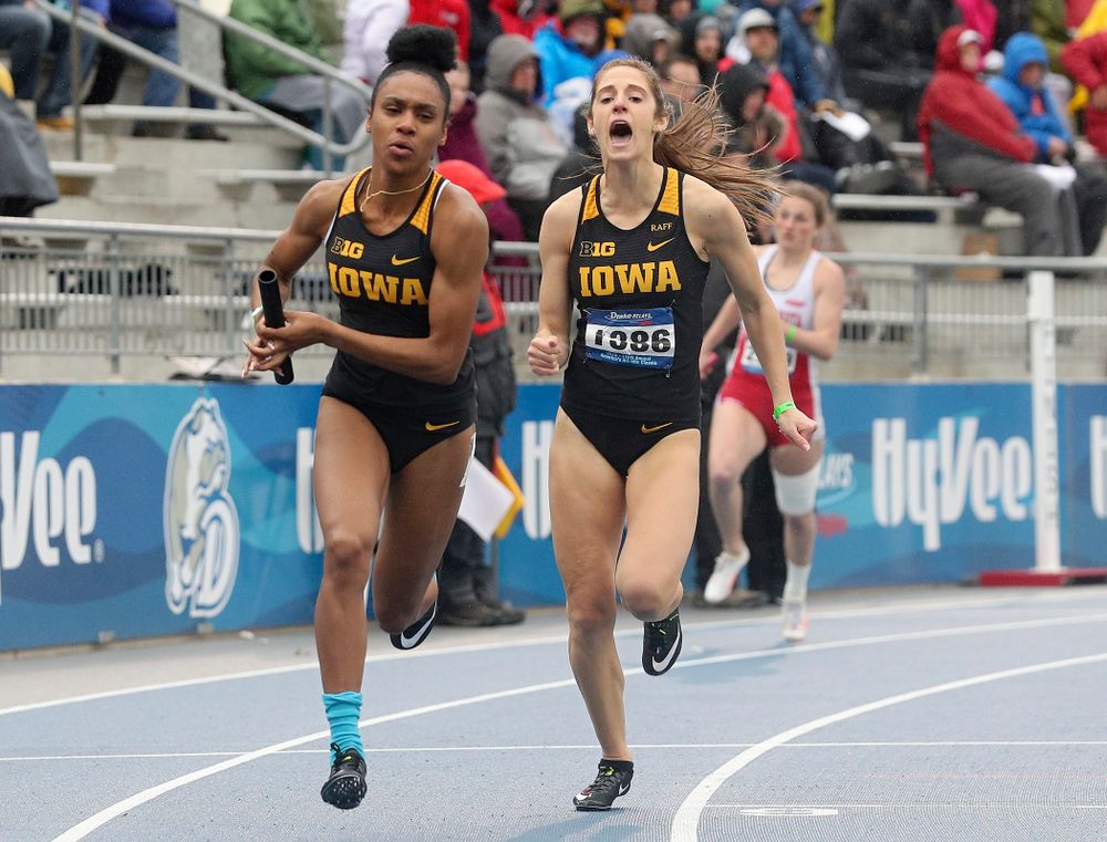 Iowa's Talia Buss (right) shouts after handing off the baton to Briana Guillory as they run the women's sprint medley relay event during the third day of the Drake Relays at Drake Stadium in Des Moines on Saturday, Apr. 27, 2019. (Stephen Mally/hawkeyesports.com)