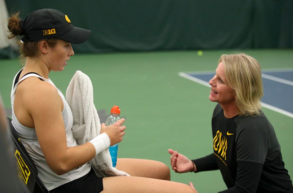 Iowa’s Elise Van Heuvelen (from left) talks with head coach Sasha Schmid during her singles match at the Hawkeye Tennis and Recreation Complex in Iowa City on Sunday, February 23, 2020. (Stephen Mally/hawkeyesports.com)