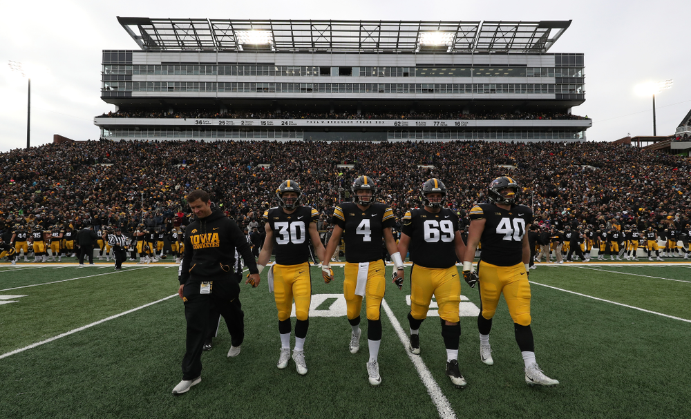 Honorary Captain Jason Baker walks to mid-field with captains Jake Gervase, Nate Stanley, Keegan Render, and Parker Hesse for the coin toss against the Northwestern Wildcats Saturday, November 10, 2018 at Kinnick Stadium. (Brian Ray/hawkeyesports.com)