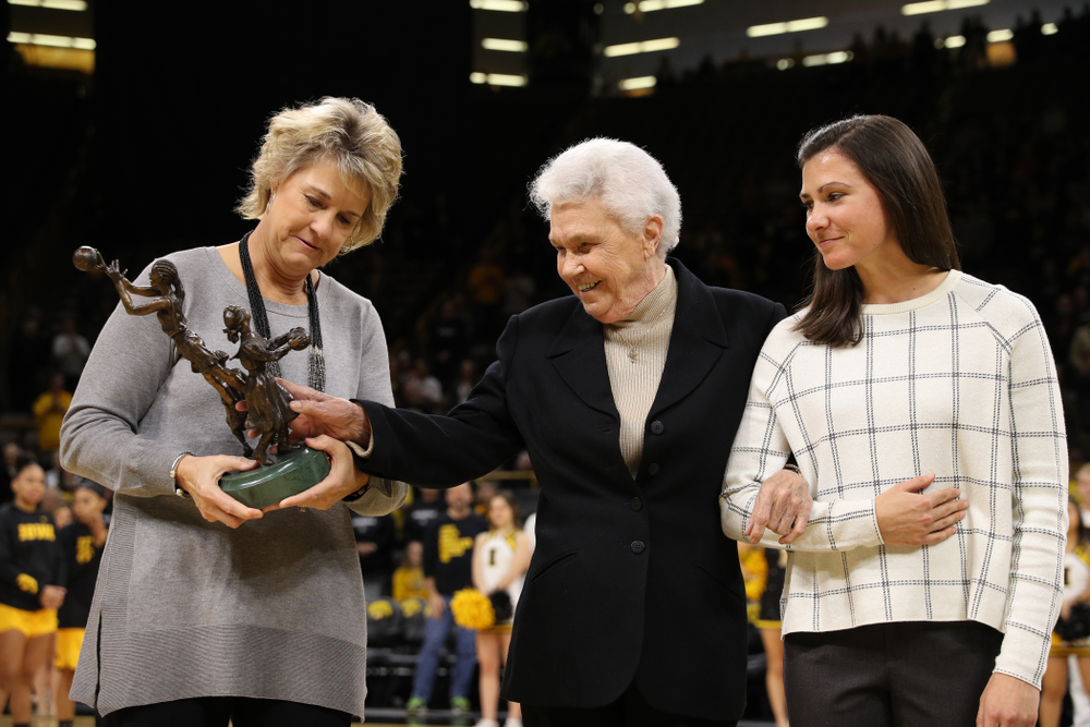 Former University of Iowa Director of Intercollegiate Athletics for Women Dr. Christine Grant receives her trophy for being inducted into the WomenÕs Basketball Hall of Fame from Iowa Hawkeyes head coach Lisa Bluder and director of basketball operations Kathryn Reynolds
before their game against the Robert Morris Colonials Sunday, December 2, 2018 at Carver-Hawkeye Arena. (Photo by Brian Ray)