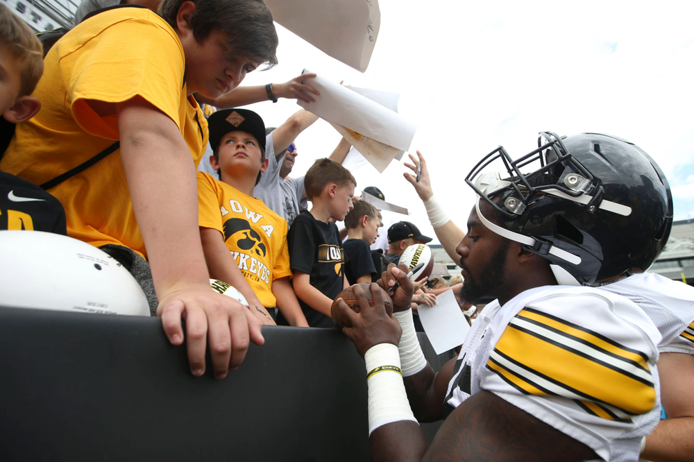 Iowa Hawkeyes linebacker Amani Jones (52) signs autographs during Kids Day at Kinnick Stadium on Saturday, August 10, 2019. (Lily Smith/hawkeyesports.com)