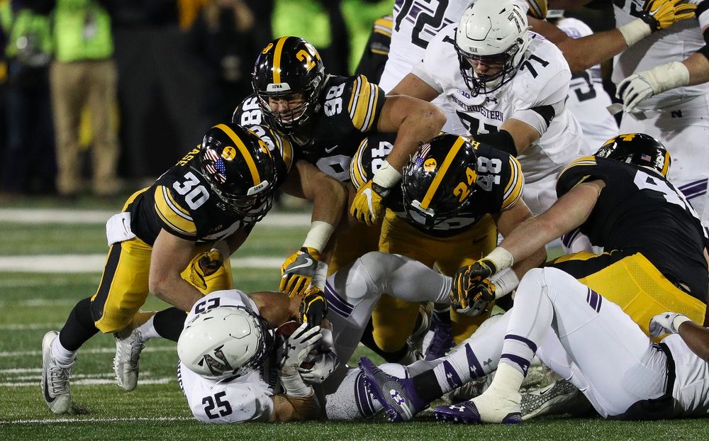 Iowa Hawkeyes defensive back Jake Gervase (30), Iowa Hawkeyes defensive end Anthony Nelson (98), Iowa Hawkeyes linebacker Jack Hockaday (48) make a tackle during a game against Northwestern at Kinnick Stadium on November 10, 2018. (Tork Mason/hawkeyesports.com)
