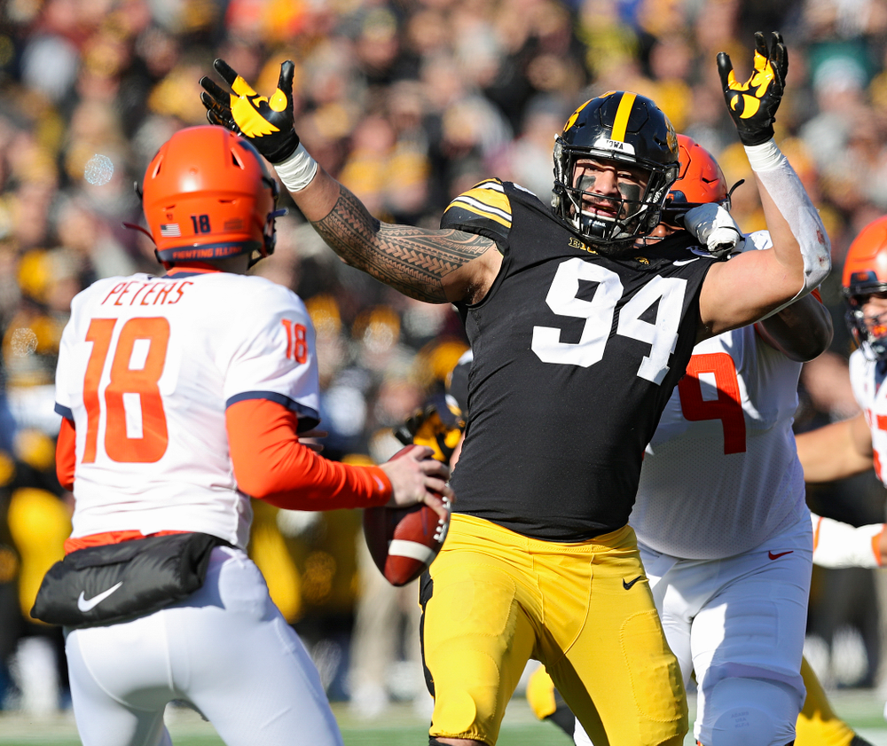Iowa Hawkeyes defensive end A.J. Epenesa (94) closes in on Illinois Fighting Illini quarterback Brandon Peters (18) during the first quarter of their game at Kinnick Stadium in Iowa City on Saturday, Nov 23, 2019. (Stephen Mally/hawkeyesports.com)