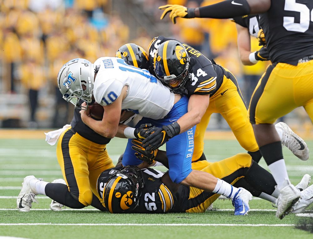 Iowa Hawkeyes defensive back Jack Koerner (28), linebacker Amani Jones (52), and linebacker Kristian Welch (34) make a tackle during third quarter of their game at Kinnick Stadium in Iowa City on Saturday, Sep 28, 2019. (Stephen Mally/hawkeyesports.com)
