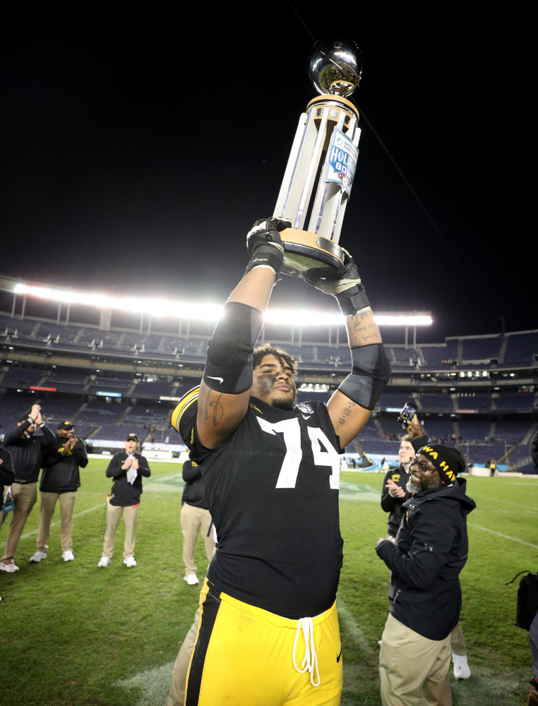 Iowa Hawkeyes offensive lineman Tristan Wirfs (74) celebrates with the Holiday Bowl trophy following their win against USC in the Holiday Bowl Friday, December 27, 2019 at San Diego Community Credit Union Stadium. (Brian Ray/hawkeyesports.com)