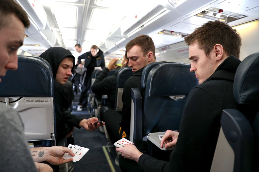 Iowa Hawkeyes guard Connor McCaffery (30), guard Austin Ash (13), forward Jack Nunge (2) forward Nicholas Baer (51) play cards on a flight to Columbus for the first and second rounds of the 2019 NCAA Men's Basketball Tournament Wednesday, March 20, 2019 at the Eastern Iowa Airport. (Brian Ray/hawkeyesports.com)