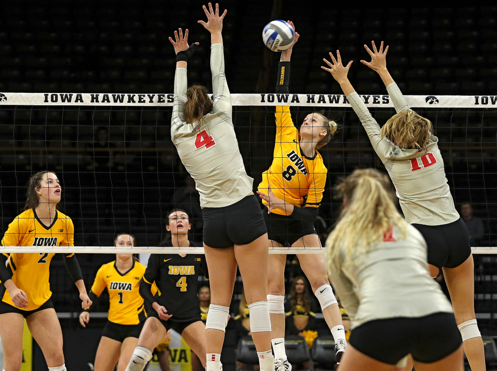 Iowa’s Kyndra Hansen (8) gets a kill between two players during the first set of their match at Carver-Hawkeye Arena in Iowa City on Friday, Nov 29, 2019. (Stephen Mally/hawkeyesports.com)