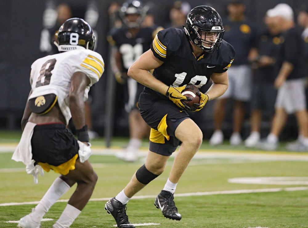 Iowa Hawkeyes tight end Drew Cook (18) pulls in a pass as defensive back Matt Hankins (8) closes in during Fall Camp Practice No. 9 at the Hansen Football Performance Center in Iowa City on Monday, Aug 12, 2019. (Stephen Mally/hawkeyesports.com)