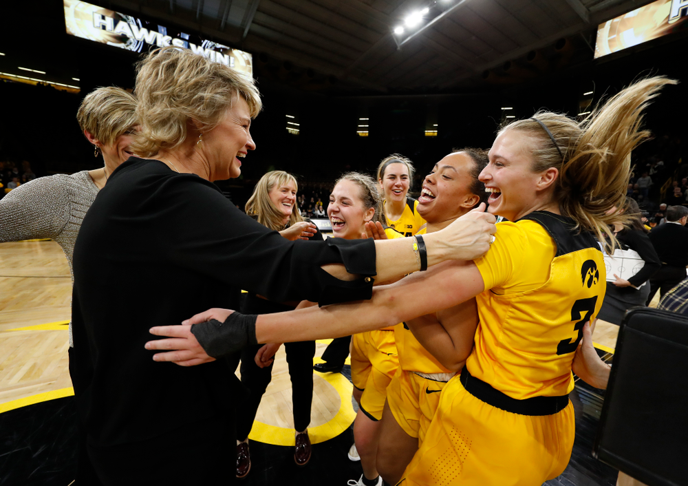 Iowa Hawkeyes head coach Lisa Bluder, guard Makenzie Meyer (3), guard Alexis Sevillian (5), and guard Kathleen Doyle (22)