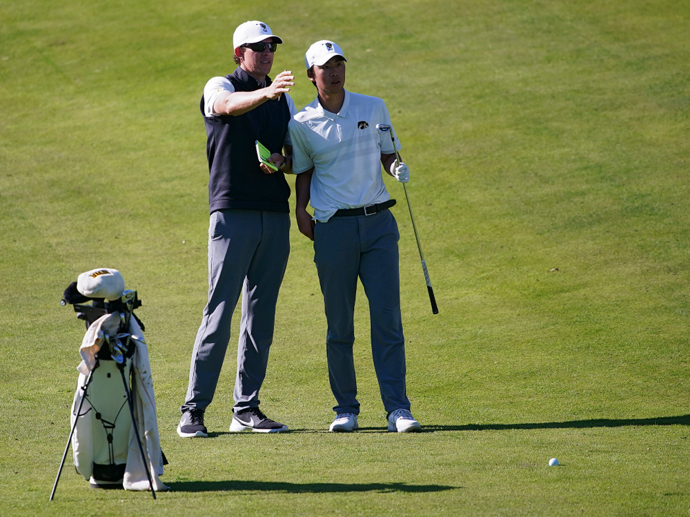 Iowa assistant coach Charlie Hoyle (from left) talks with Joe Kim during the second round of the Hawkeye Invitational at Finkbine Golf Course in Iowa City on Saturday, Apr. 20, 2019. (Stephen Mally/hawkeyesports.com)