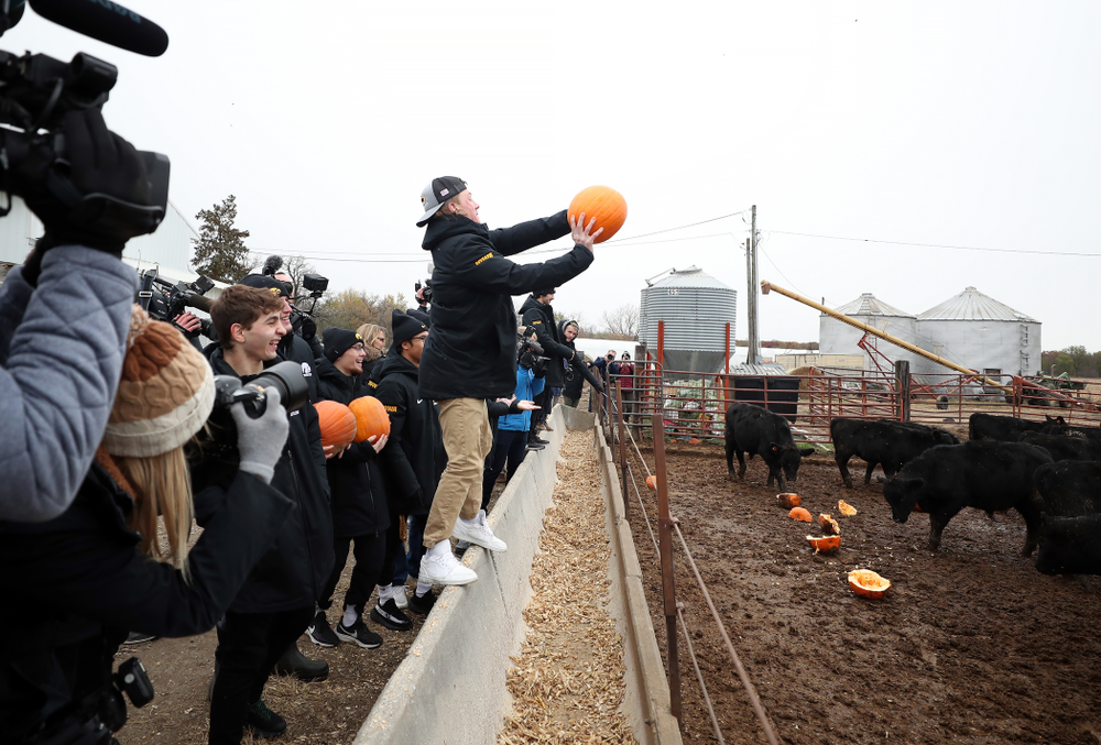 Wrestler Max Murin tosses a pumpkin into the cow pen during the teamÕs annual media day Wednesday, October 30, 2019 at Kroul Family Farms in Mount Vernon. (Brian Ray/hawkeyesports.com)