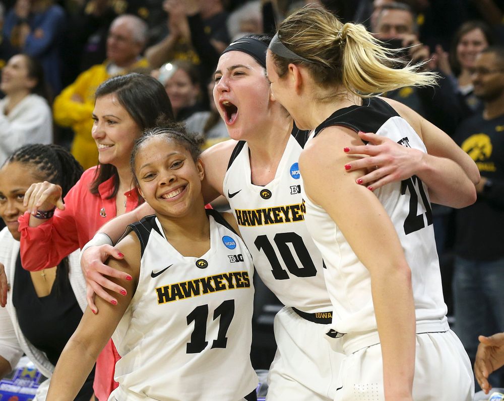 Iowa Hawkeyes guard Tania Davis (11), center Megan Gustafson (10), and forward Hannah Stewart (21) hug in the closing seconds of the fourth quarter of their second round game in the 2019 NCAA Women's Basketball Tournament at Carver Hawkeye Arena in Iowa City on Sunday, Mar. 24, 2019. (Stephen Mally for hawkeyesports.com)