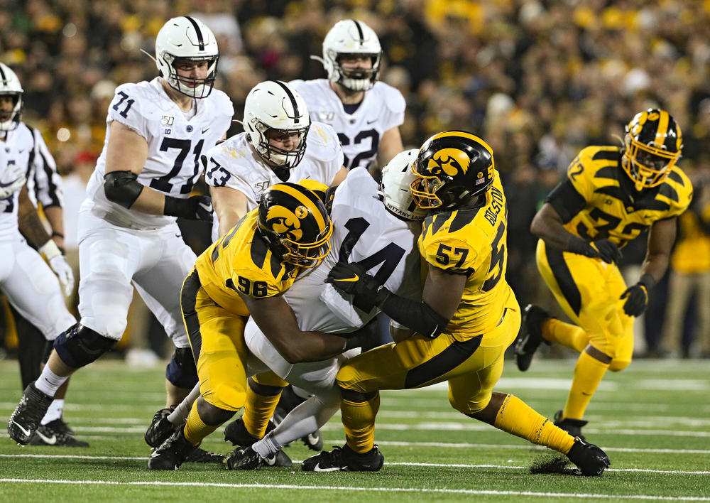 Iowa Hawkeyes defensive lineman Cedrick Lattimore (96) and defensive end Chauncey Golston (57) bring down Penn State Nittany Lions quarterback Sean Clifford (14) during the third quarter of their game at Kinnick Stadium in Iowa City on Saturday, Oct 12, 2019. (Stephen Mally/hawkeyesports.com)