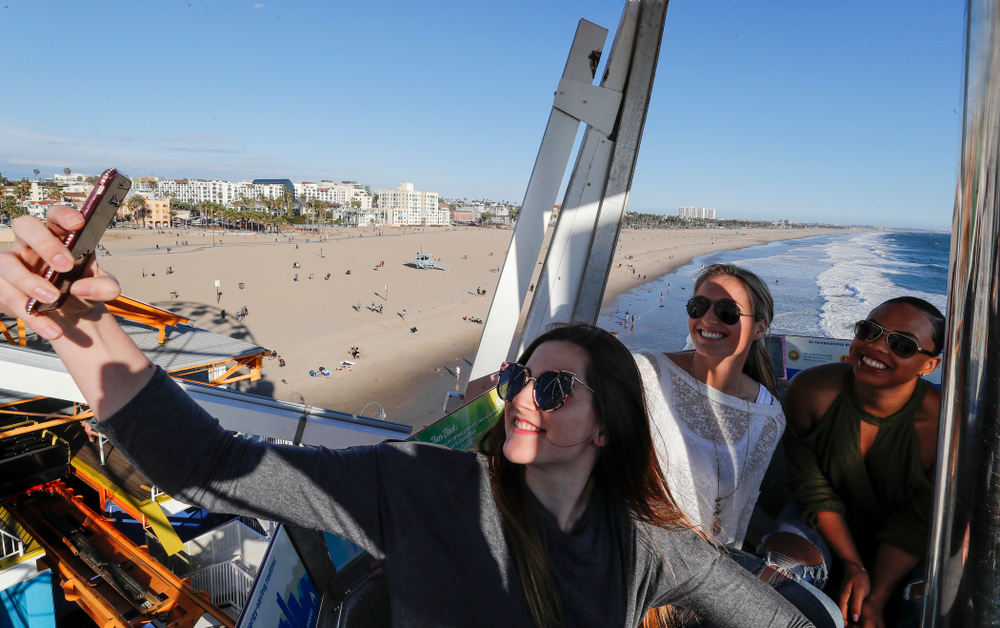 Iowa Hawkeyes forward Megan Gustafson (10) takes a selfie with guard Makenzie Meyer (3), guard Alexis Sevillian (5) and guard Tania Davis (11) as they ride the ferris wheel in Pacific Park on the Santa Monica Pier Thursday, March 15, 2018 in Santa Monica. (Brian Ray/hawkeyesports.com)