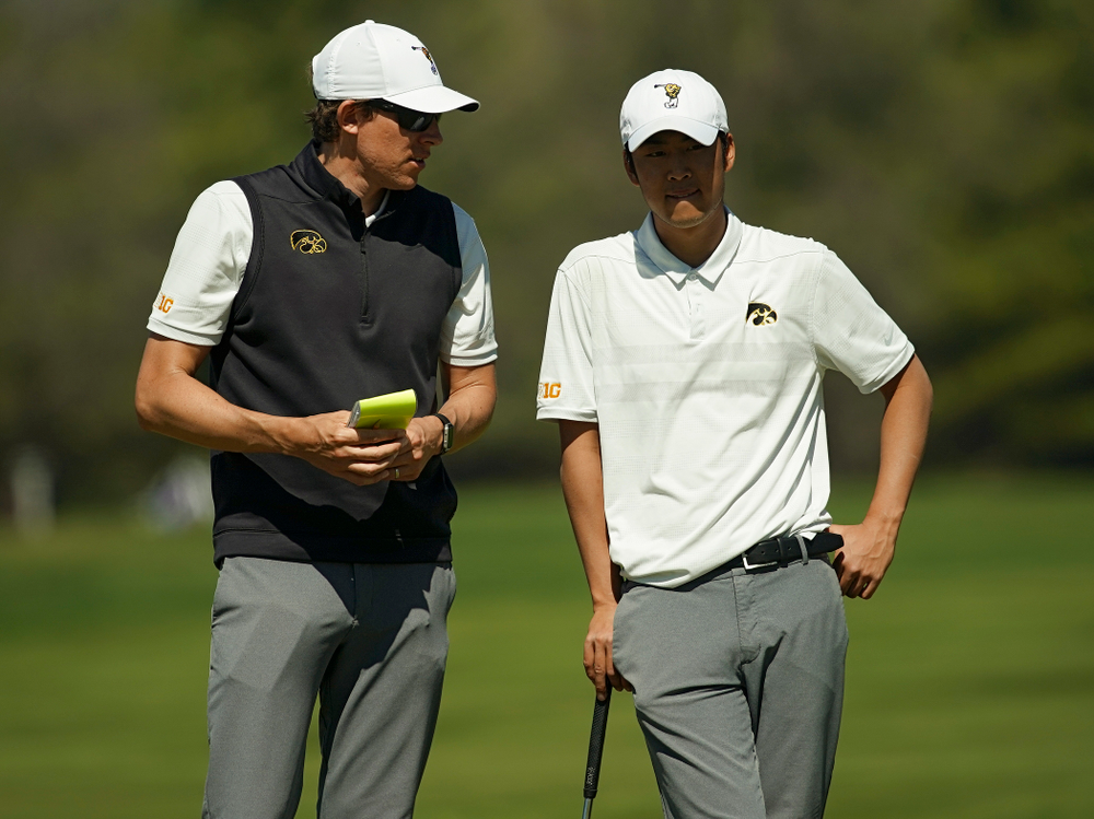 Iowa assistant coach Charlie Hoyle (from left) talks with Joe Kim during the second round of the Hawkeye Invitational at Finkbine Golf Course in Iowa City on Saturday, Apr. 20, 2019. (Stephen Mally/hawkeyesports.com)