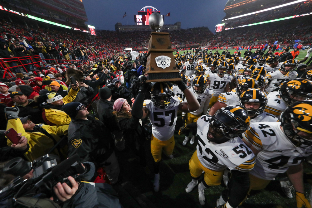 Iowa Hawkeyes defensive end Chauncey Golston (57) carries the Heroes Game trophy off the field following their win against the Nebraska Cornhuskers Friday, November 29, 2019 at Memorial Stadium in Lincoln, Neb. (Brian Ray/hawkeyesports.com)