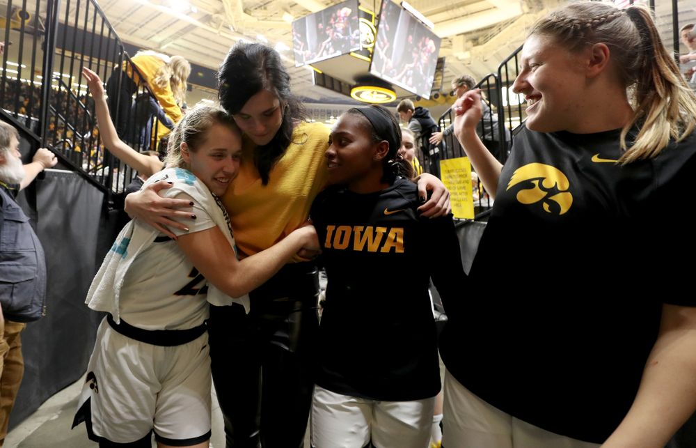 Megan Gustafson hugs Iowa Hawkeyes guard Kathleen Doyle (22) and guard Zion Sanders (21) following a jersey retirement ceremony Sunday, January 26, 2020 at Carver-Hawkeye Arena. (Brian Ray/hawkeyesports.com)
