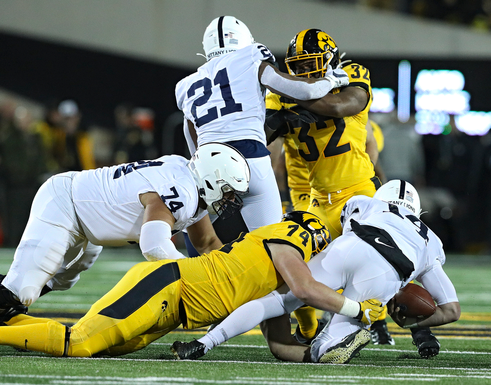 Iowa Hawkeyes defensive lineman Austin Schulte (74) brings down Penn State Nittany Lions quarterback Sean Clifford (14) for a loss during the first quarter of their game at Kinnick Stadium in Iowa City on Saturday, Oct 12, 2019. (Stephen Mally/hawkeyesports.com)