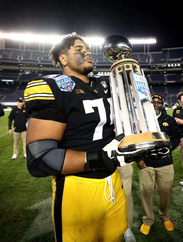 Iowa Hawkeyes offensive lineman Tristan Wirfs (74) celebrates with the Holiday Bowl trophy following their win against USC in the Holiday Bowl Friday, December 27, 2019 at San Diego Community Credit Union Stadium. (Brian Ray/hawkeyesports.com)