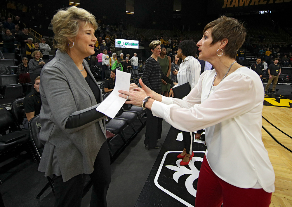 Iowa Hawkeyes head coach Lisa Bluder (from left) shakes hands with Indiana Hoosiers head coach Teri Moren before the start of their game at Carver-Hawkeye Arena in Iowa City on Sunday, January 12, 2020. (Stephen Mally/hawkeyesports.com)