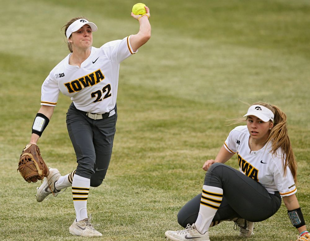 Iowa Hawkeyes Hallie Ketcham (22) throws the ball as Sydney Owens (5) looks on during the second inning of their Big Ten Conference softball game at Pearl Field in Iowa City on Friday, Mar. 29, 2019. (Stephen Mally/hawkeyesports.com)