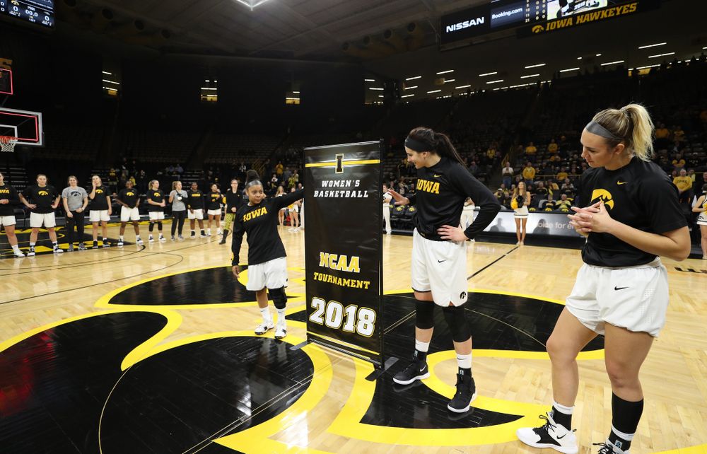 Iowa Hawkeyes guard Tania Davis (11), forward Megan Gustafson (10), and forward Hannah Stewart (21) unveil their NCAA banner before their game against Oral Roberts University Friday, November 9, 2018 at Carver-Hawkeye Arena. (Brian Ray/hawkeyesports.com)