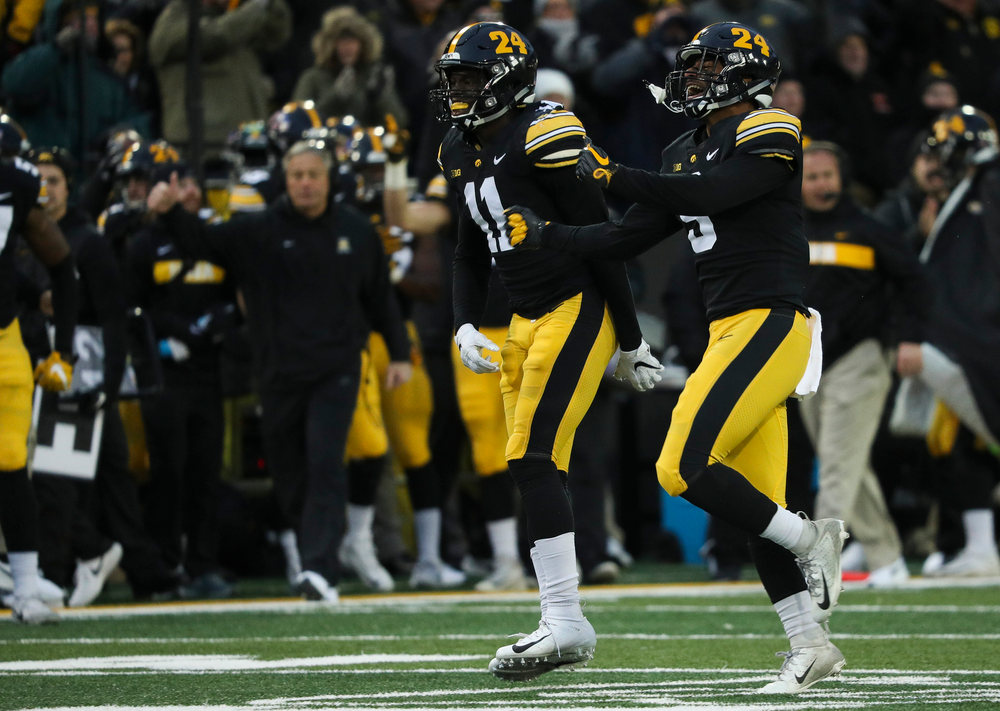 Iowa Hawkeyes defensive back Michael Ojemudia (11) and Iowa Hawkeyes defensive back Geno Stone (9) react after Stone's interception during a game against Northwestern at Kinnick Stadium on November 10, 2018. (Tork Mason/hawkeyesports.com)