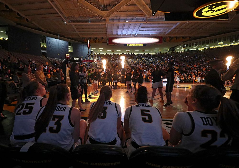Iowa Hawkeyes forward Monika Czinano (25), forward Amanda Ollinger (43), guard Makenzie Meyer (3), guard Alexis Sevillian (5), and guard Kathleen Doyle (22) sit on the bench as they wait to be introduced before the game at Carver-Hawkeye Arena in Iowa City on Thursday, February 6, 2020. (Stephen Mally/hawkeyesports.com)