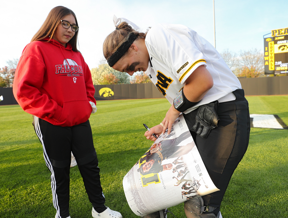 Iowa's Abby Lien (9) signs a poster for a fan after winning their game against Ohio State at Pearl Field in Iowa City on Friday, May. 3, 2019. (Stephen Mally/hawkeyesports.com)