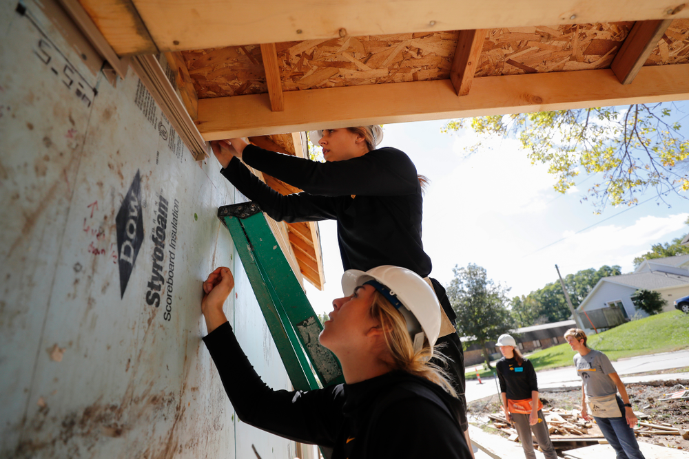 Iowa Hawkeyes guard Kathleen Doyle (22) and forward Hannah Stewart (21) work on the Habitat for Humanity Women's Build Wednesday, September 26, 2018 in Iowa City. (Brian Ray/hawkeyesports.com)