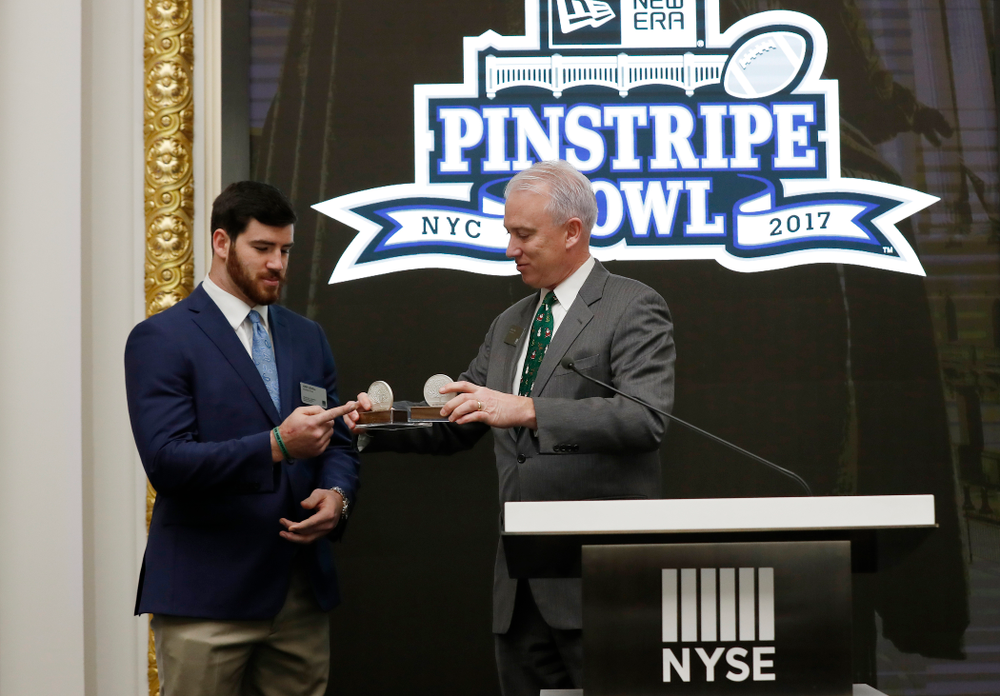 Iowa Hawkeyes linebacker Josey Jewell (43), defensive back Joshua Jackson (15), offensive lineman Sean Welsh (79) and head coach Kirk Ferentz ring the opening bell at the New York Stock Exchange Tuesday, December 26, 2017 in New York. (Brian Ray/hawkeyesports.com)
