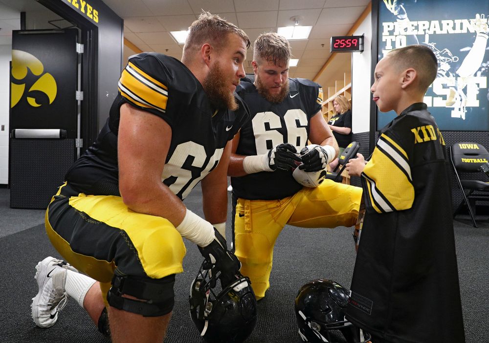 Iowa Hawkeyes offensive lineman Landan Paulsen (68) and offensive lineman Levi Paulsen (66) talk with Kid Captain Skylar Hardee during Kids Day at Kinnick Stadium in Iowa City on Saturday, Aug 10, 2019. (Stephen Mally/hawkeyesports.com)