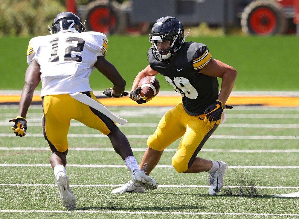 Iowa Hawkeyes wide receiver Nico Ragaini (89) avoids defensive back D.J. Johnson (12) during Fall Camp Practice #5 at the Hansen Football Performance Center in Iowa City on Tuesday, Aug 6, 2019. (Stephen Mally/hawkeyesports.com)